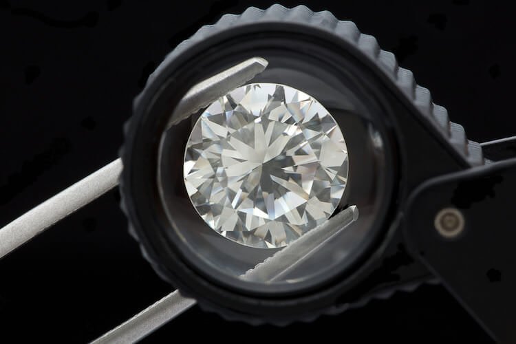 Ein Diamant bei seiner Prüfung zwischen einer Pinzette Diamanten Schliff unterschiedlicher Schliffgrade auf Bildern - Ein Diamant bei seiner Prüfung eingeklemmt in einer Pinzette